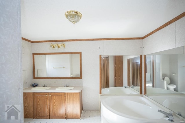 bathroom featuring a tub to relax in, crown molding, vanity, and toilet