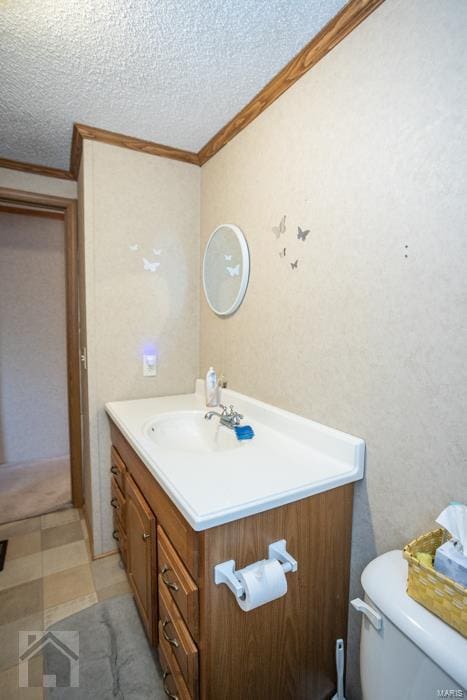 bathroom featuring a textured ceiling, vanity, toilet, and crown molding