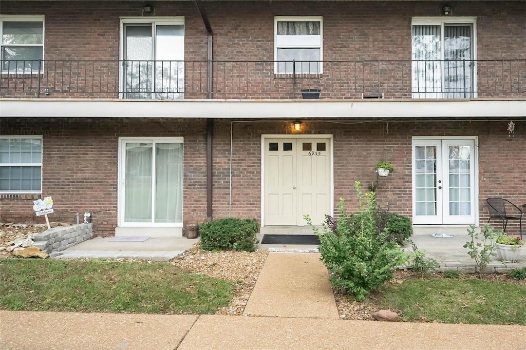 property entrance featuring a balcony and french doors