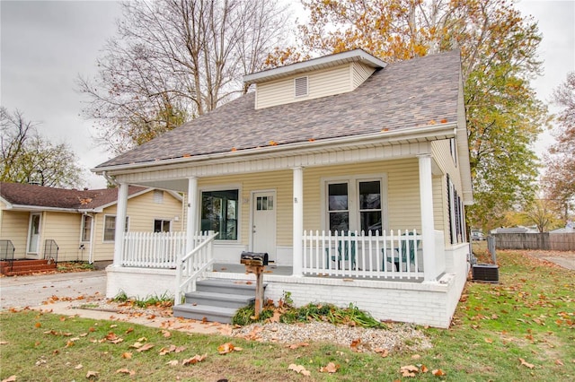 bungalow-style home featuring a porch and a front lawn