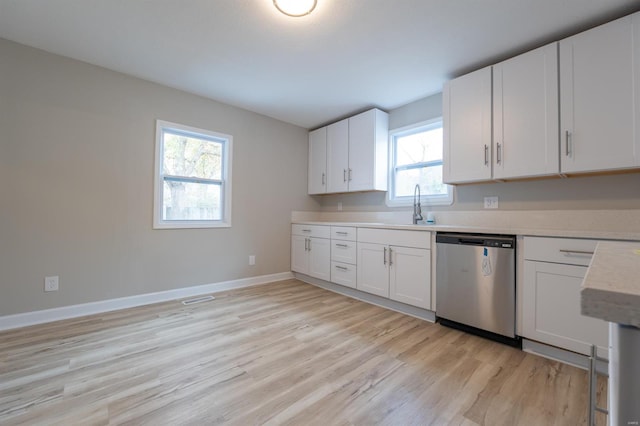 kitchen featuring sink, white cabinetry, stainless steel dishwasher, and light hardwood / wood-style flooring