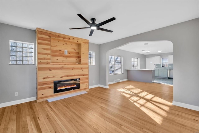 unfurnished living room with ceiling fan and light hardwood / wood-style flooring