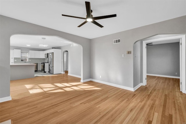 unfurnished living room featuring ceiling fan and light hardwood / wood-style flooring