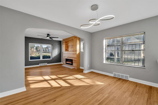 unfurnished living room with a fireplace, hardwood / wood-style floors, and ceiling fan