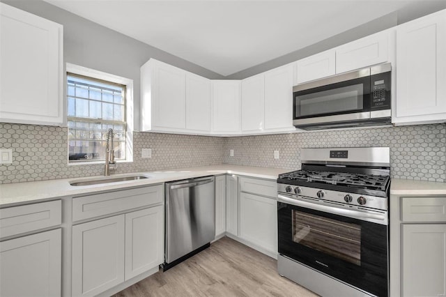 kitchen with tasteful backsplash, white cabinets, and stainless steel appliances