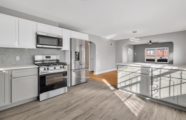 kitchen with ceiling fan, light hardwood / wood-style flooring, white cabinets, and stainless steel appliances