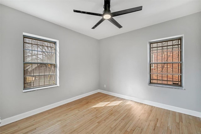 spare room with ceiling fan, plenty of natural light, and light wood-type flooring