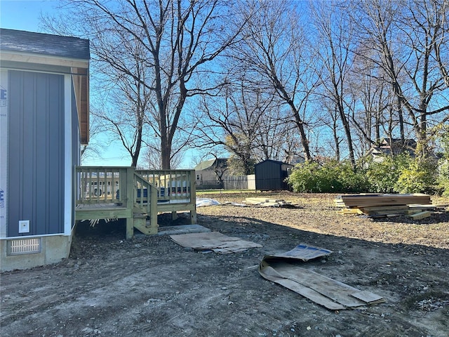 view of yard with a deck and a storage unit