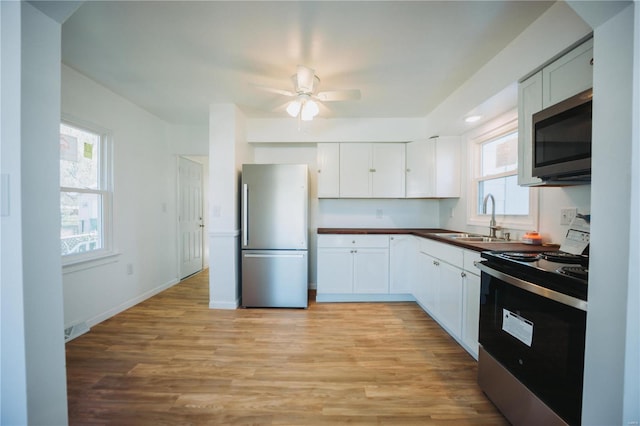 kitchen featuring white cabinetry, sink, a wealth of natural light, and stainless steel appliances