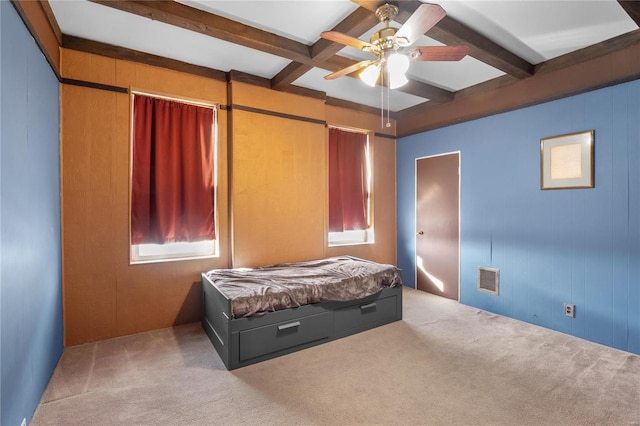 carpeted bedroom featuring beam ceiling, ceiling fan, and wooden walls