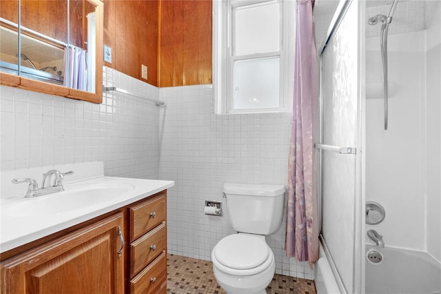 full bathroom featuring tile patterned flooring, toilet, shower / bath combo with shower curtain, vanity, and tile walls