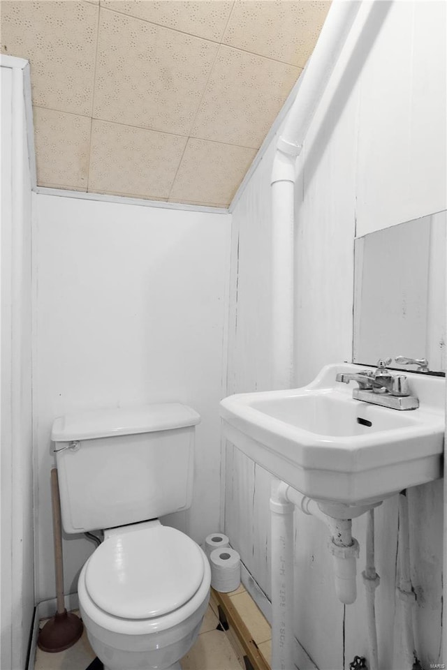 bathroom with a paneled ceiling and toilet