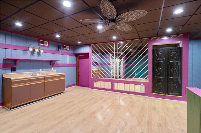 bar featuring ceiling fan, a drop ceiling, light wood-type flooring, and sink