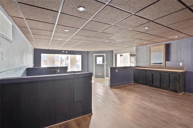 kitchen featuring hardwood / wood-style floors and a drop ceiling