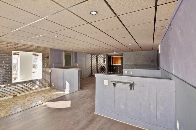 kitchen with a paneled ceiling and wood-type flooring