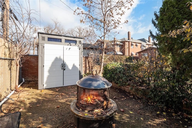 view of yard featuring a fire pit and a shed