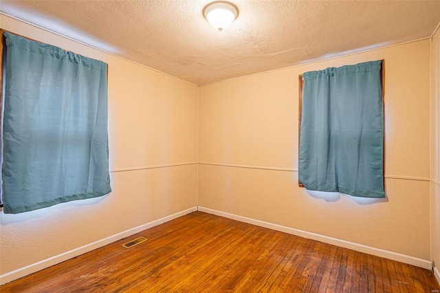 empty room featuring hardwood / wood-style floors and a textured ceiling