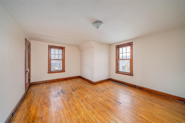 bonus room with a textured ceiling and light wood-type flooring