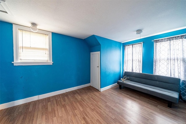 unfurnished room with hardwood / wood-style flooring and a textured ceiling