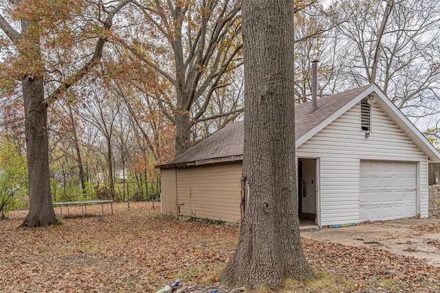 exterior space featuring an outbuilding, a garage, and a trampoline