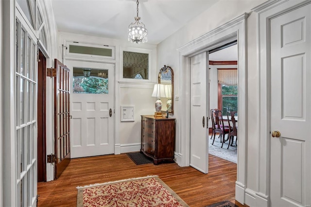 foyer entrance featuring dark wood-type flooring and an inviting chandelier