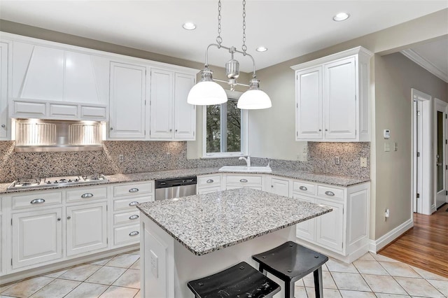 kitchen featuring pendant lighting, white cabinets, light tile patterned floors, and stainless steel appliances