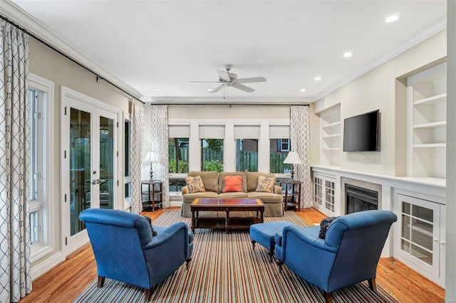 living room with ceiling fan, french doors, wood-type flooring, and ornamental molding