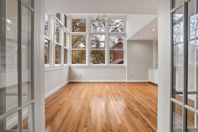 unfurnished sunroom featuring ceiling fan