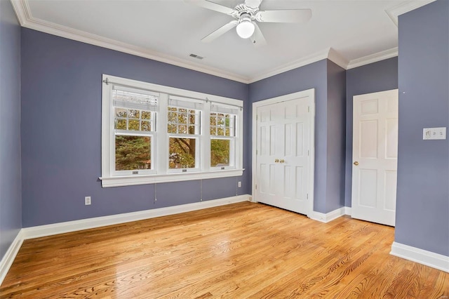 unfurnished bedroom featuring ceiling fan, light hardwood / wood-style floors, crown molding, and a closet