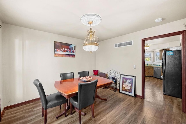 dining room with dark hardwood / wood-style floors and sink