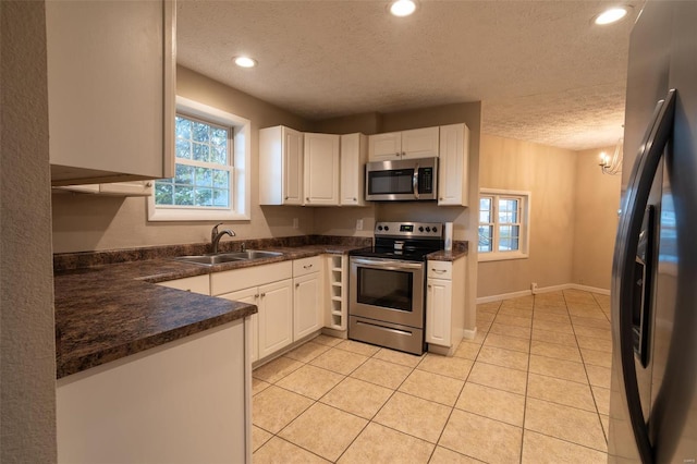 kitchen featuring sink, plenty of natural light, white cabinets, and appliances with stainless steel finishes