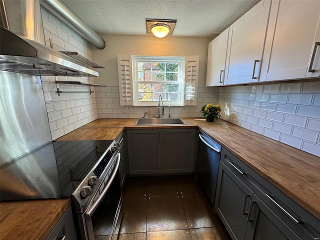 kitchen featuring butcher block counters, sink, and white cabinets