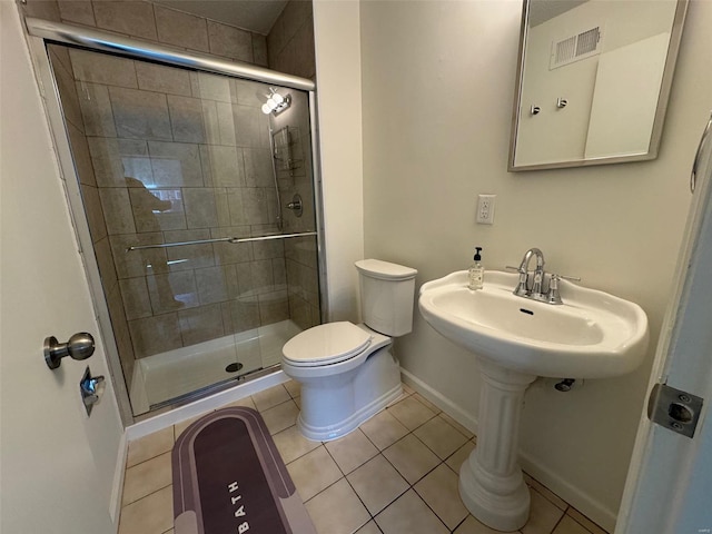 bathroom featuring tile patterned floors, toilet, and walk in shower