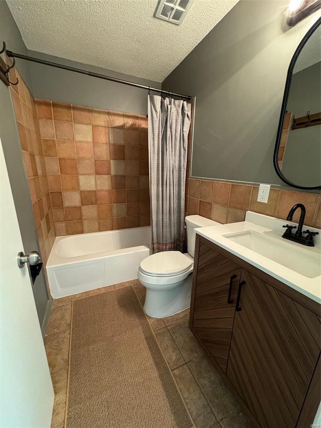 full bathroom with tile patterned floors, toilet, a textured ceiling, and shower / tub combo