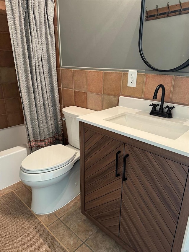 full bathroom featuring tile patterned floors, shower / bath combo with shower curtain, vanity, and tile walls