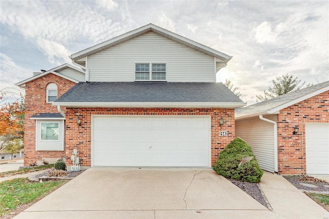 traditional home featuring an attached garage, roof with shingles, driveway, and brick siding