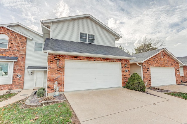 traditional home featuring a shingled roof, brick siding, and driveway