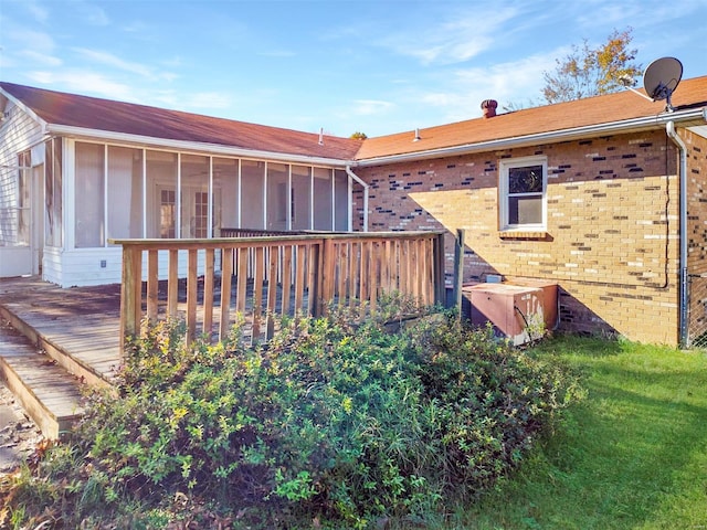 back of property with a wooden deck and a sunroom