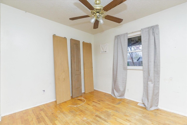 unfurnished bedroom with ceiling fan, a textured ceiling, and light hardwood / wood-style flooring