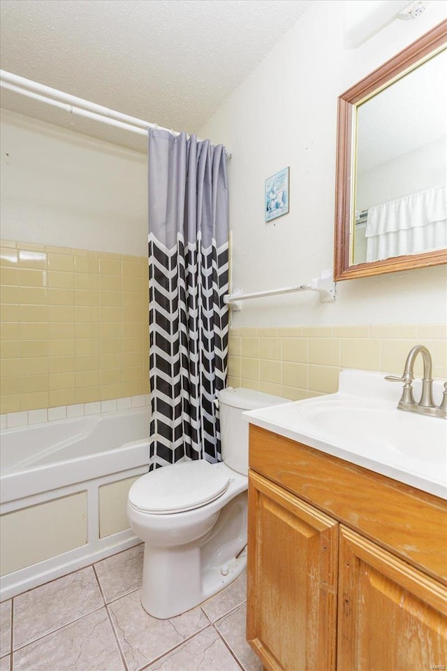 full bathroom featuring shower / bath combination with curtain, tile patterned floors, vanity, tile walls, and toilet