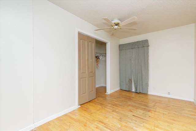 unfurnished bedroom featuring ceiling fan, light hardwood / wood-style flooring, and a textured ceiling