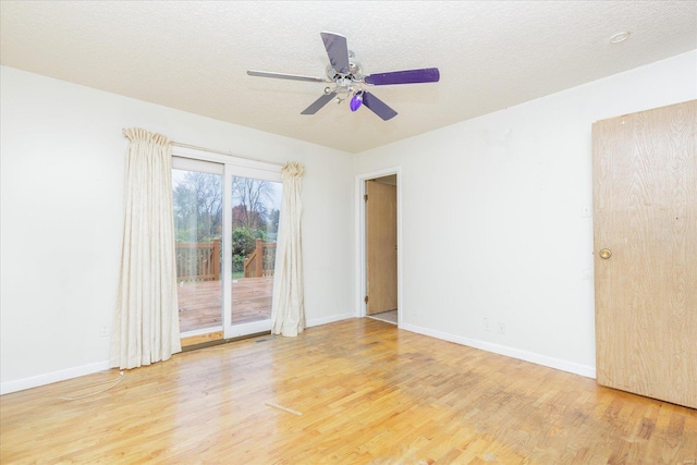 empty room with ceiling fan, wood-type flooring, and a textured ceiling