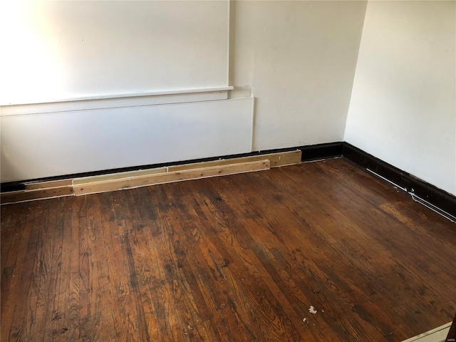 empty room with dark hardwood / wood-style flooring