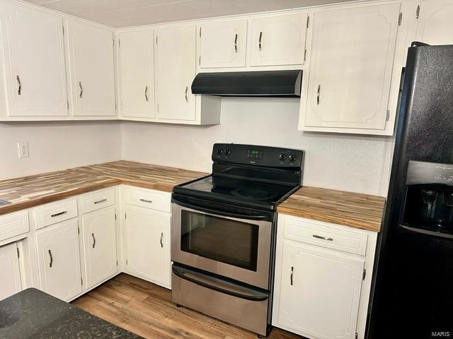 kitchen with light wood-type flooring, black refrigerator with ice dispenser, extractor fan, stainless steel electric stove, and white cabinetry