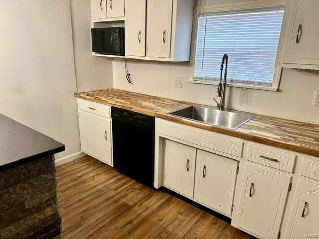 kitchen featuring white cabinets, sink, butcher block countertops, and black appliances