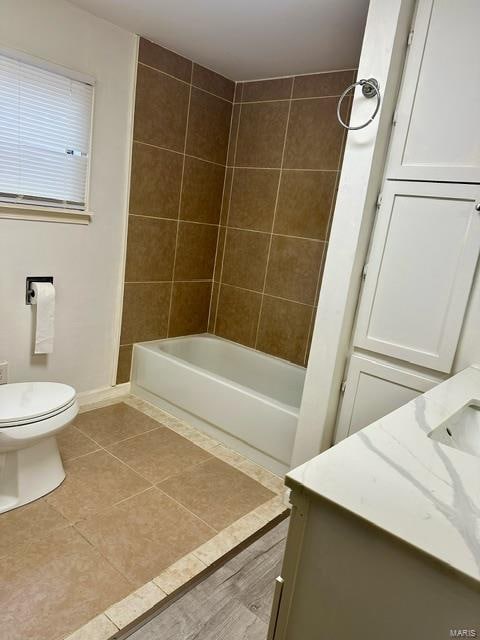 full bathroom with toilet, vanity, tile patterned floors, and tiled shower / bath combo