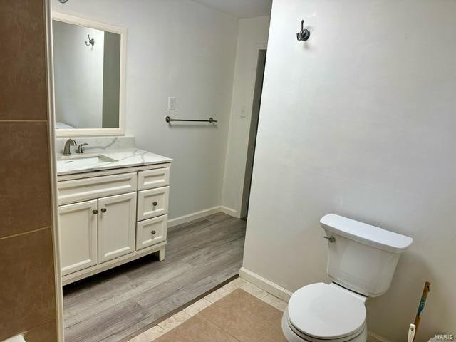 bathroom featuring wood-type flooring, vanity, and toilet