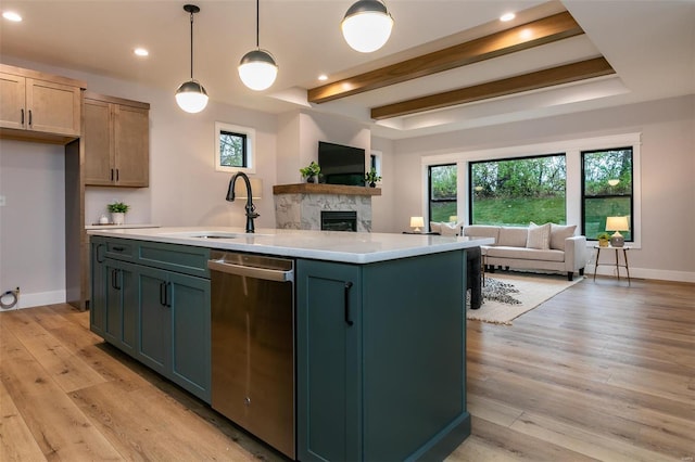 kitchen featuring sink, a center island with sink, dishwasher, pendant lighting, and light hardwood / wood-style floors