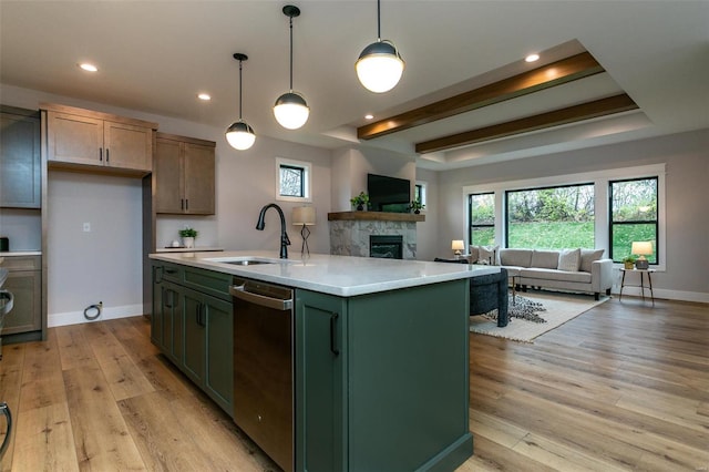 kitchen featuring sink, hanging light fixtures, a kitchen island with sink, stainless steel dishwasher, and light hardwood / wood-style floors