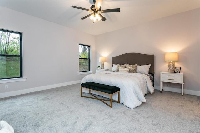 bedroom with multiple windows, light carpet, and ceiling fan